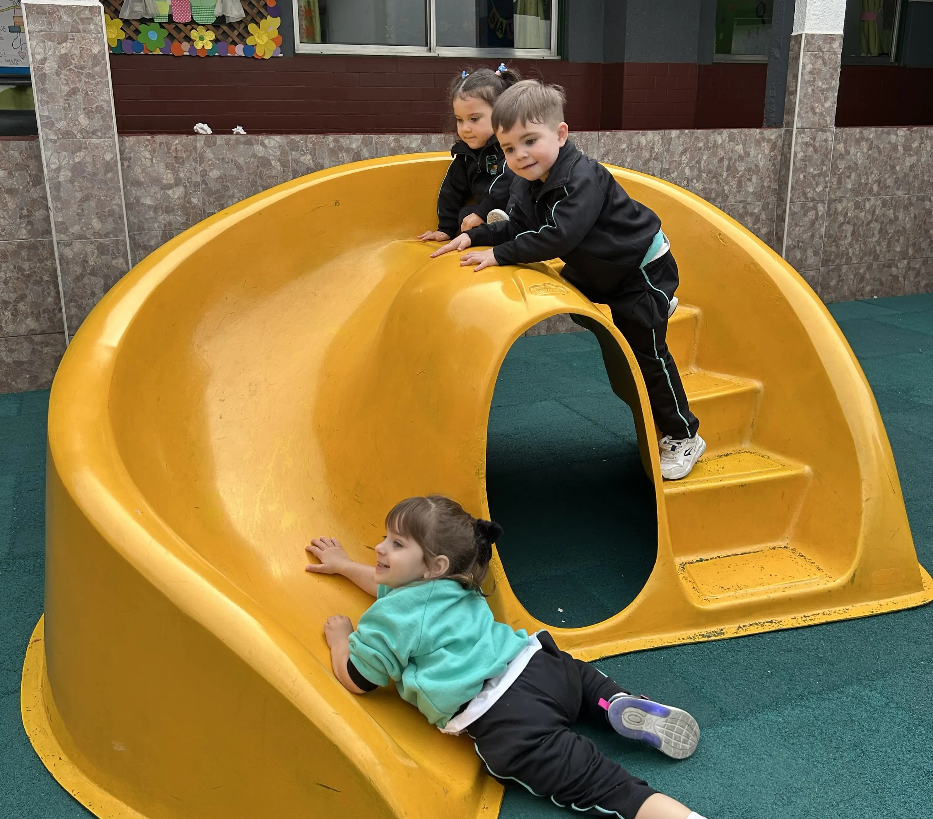 Niños del Nivel Inicial del Colegio Echeverría participando en actividades de juego y desarrollo motriz en el patio escolar.