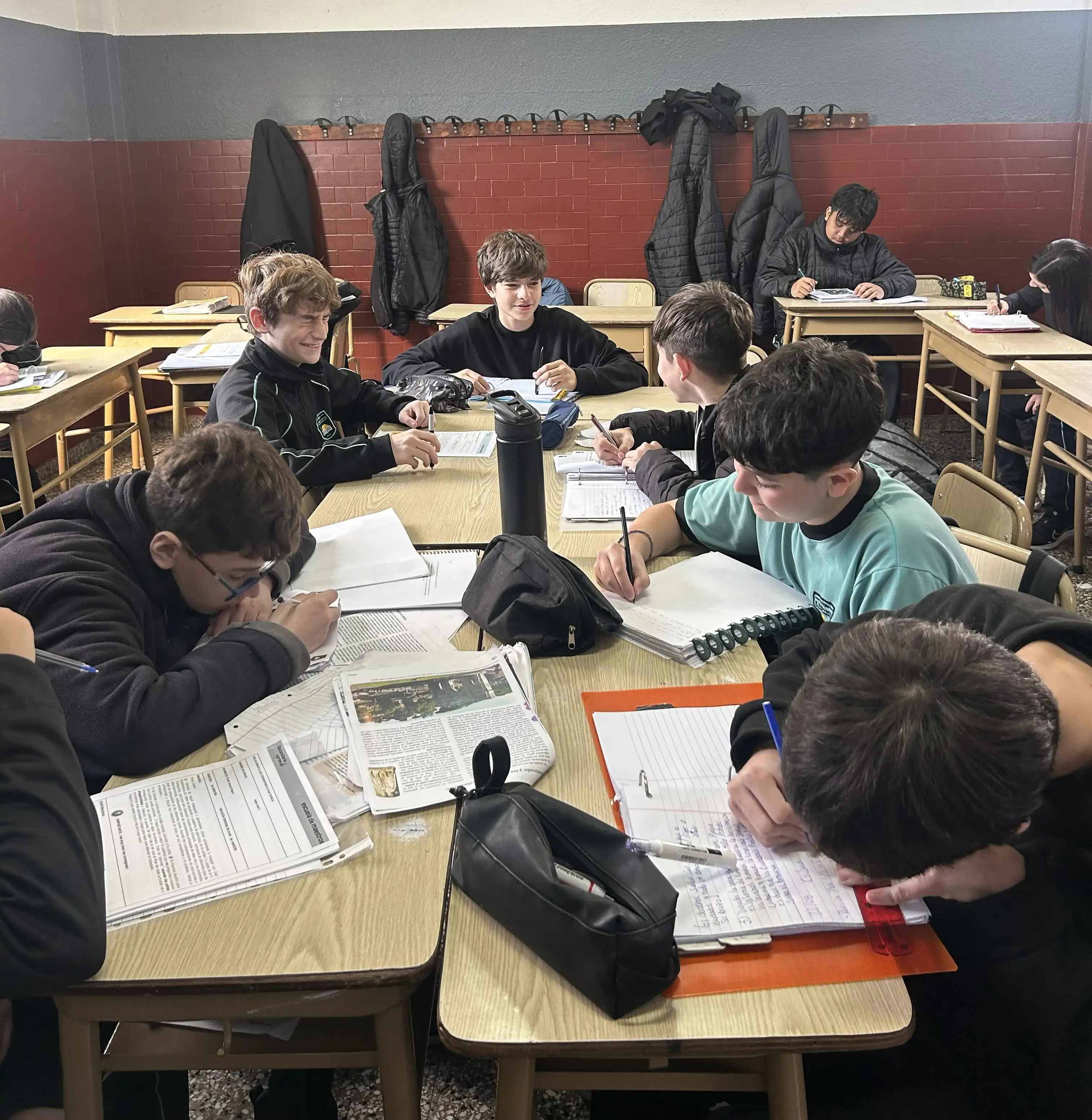 Estudiantes del Nivel Secundario del Colegio Echeverría participando en actividades de trabajo colaborativo y resolución de consignas en el aula.